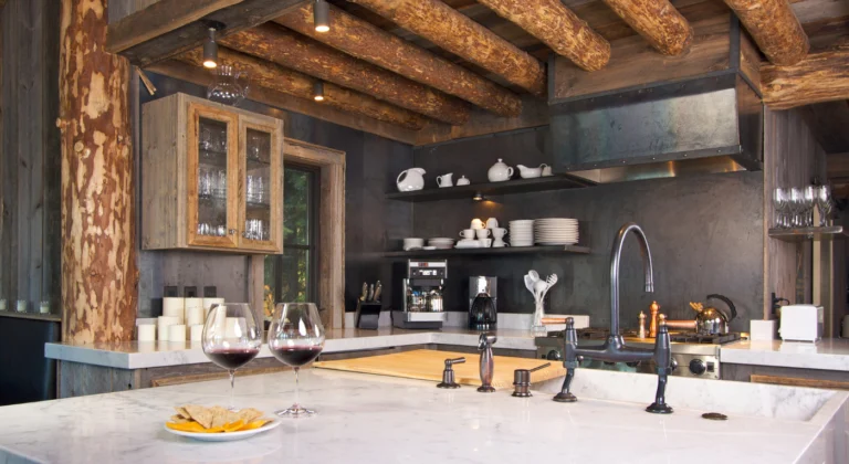 Kitchen with exposed wood ceiling beams, dark cabinets and a pale island countertop