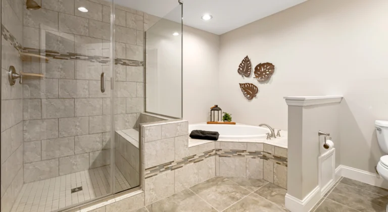 Bathroom with a glass shower, pale tile and a corner bathtub